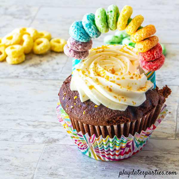 Rainbow cupcake toppers in a chocolate cupcake with gold sprinkles
