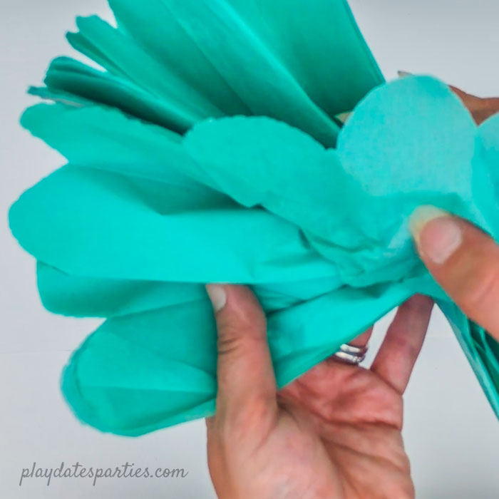 Opening the pom pom from the center and not the edges