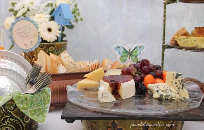 A pretty cheese board for a Mother's Day brunch with blue and green accents