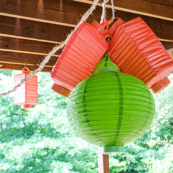 A chandelier made with battery-operated lanterns in orange and green.