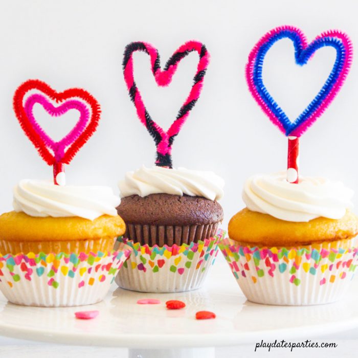 3 cupcakes decorated with heart shaped cupcake toppers