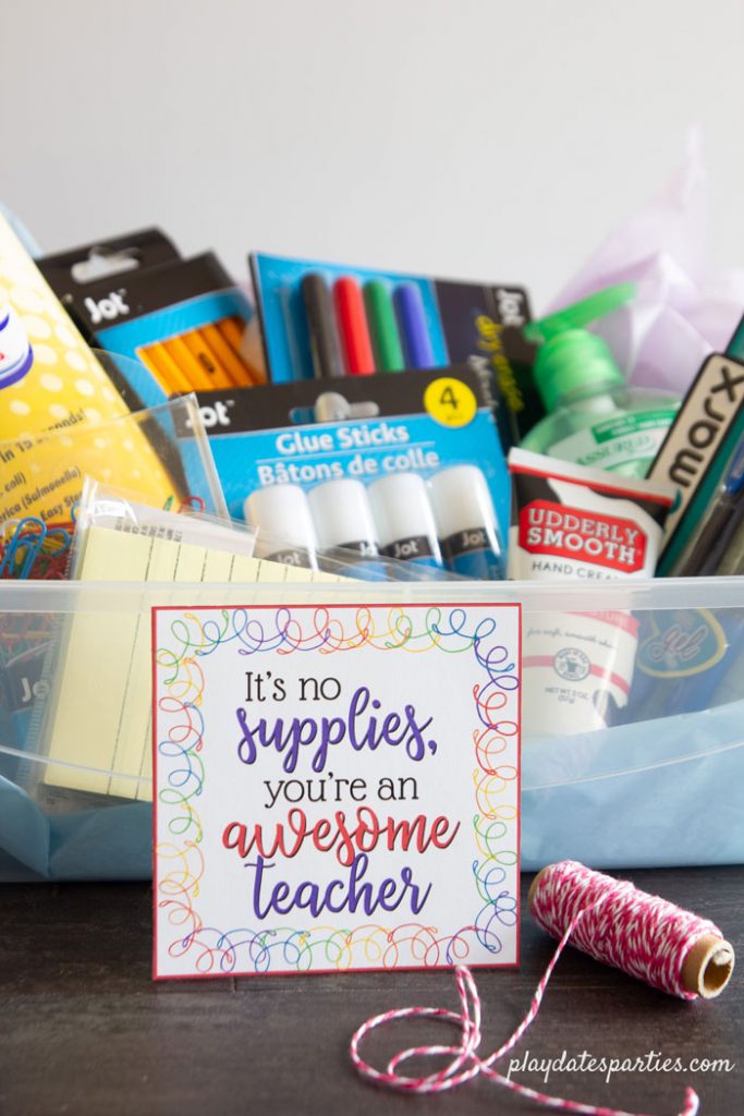 A photo of school supplies in a box with a teacher appreciation tag that say it's no supplies you're an awesome teacher.