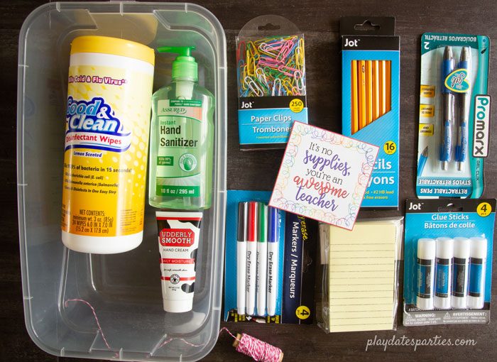 A photo of teacher supplies laid out on a table with a colorful tag in the center