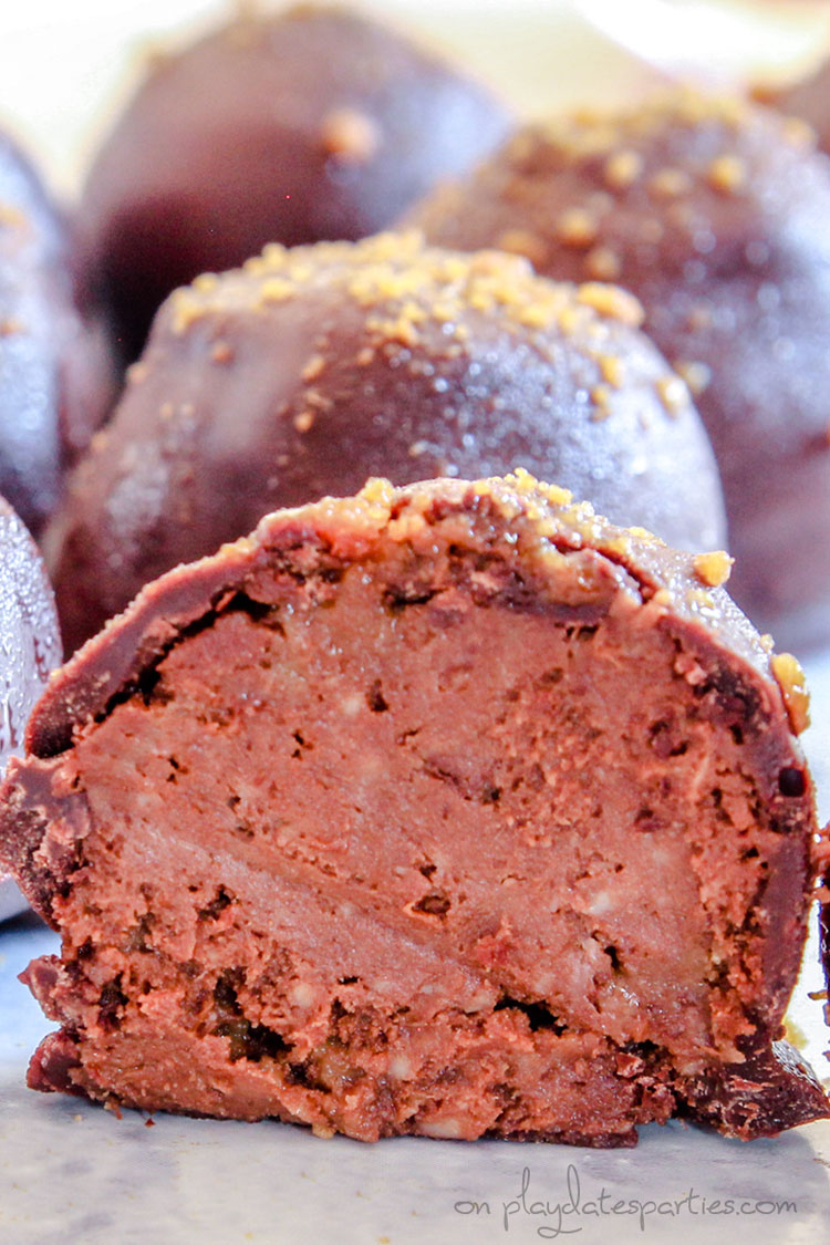 A chocolate truffle cut in half, revealing the creamy chocolate pumpkin filling.