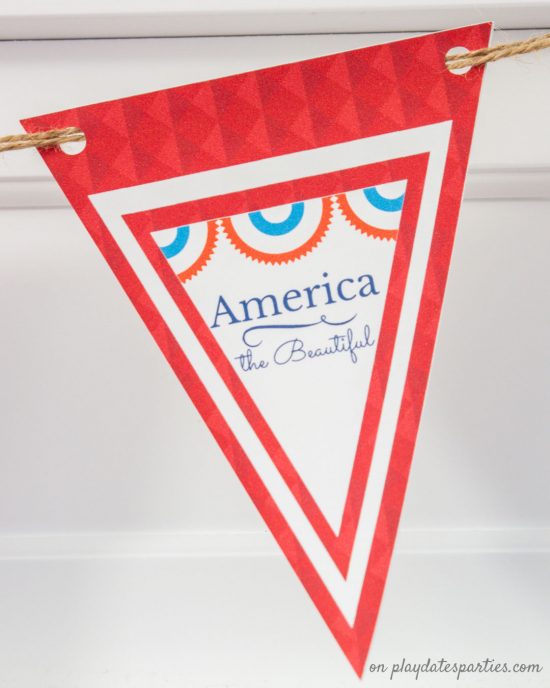 A close up of a triangular printable party banner that says America the Beautiful