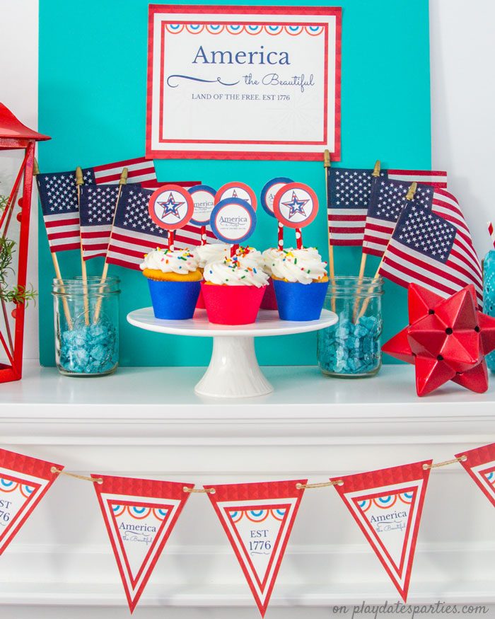 A picture of the full set of Independence Day printables displayed on a mantel with American flags