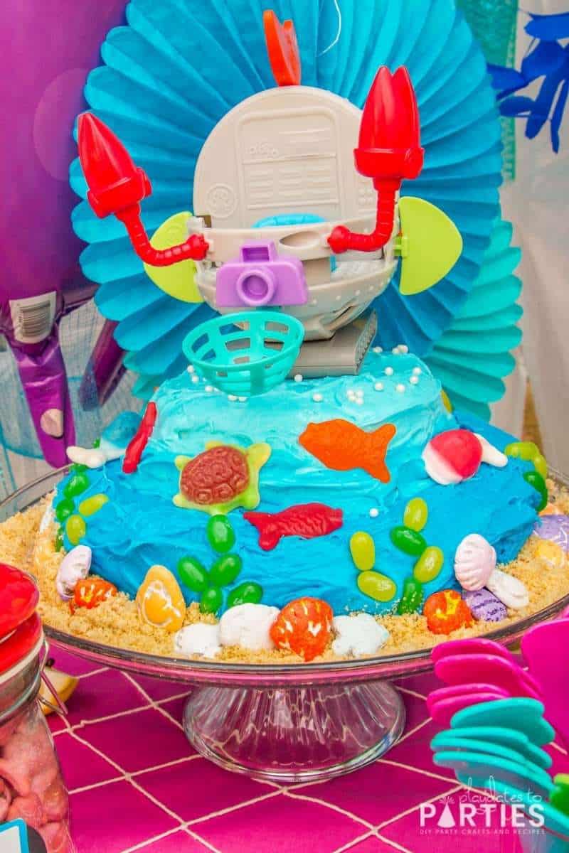 Octonauts party cake with ombre blue frosting, jelly bean seaweed, gummy fish, and chocolate seashells