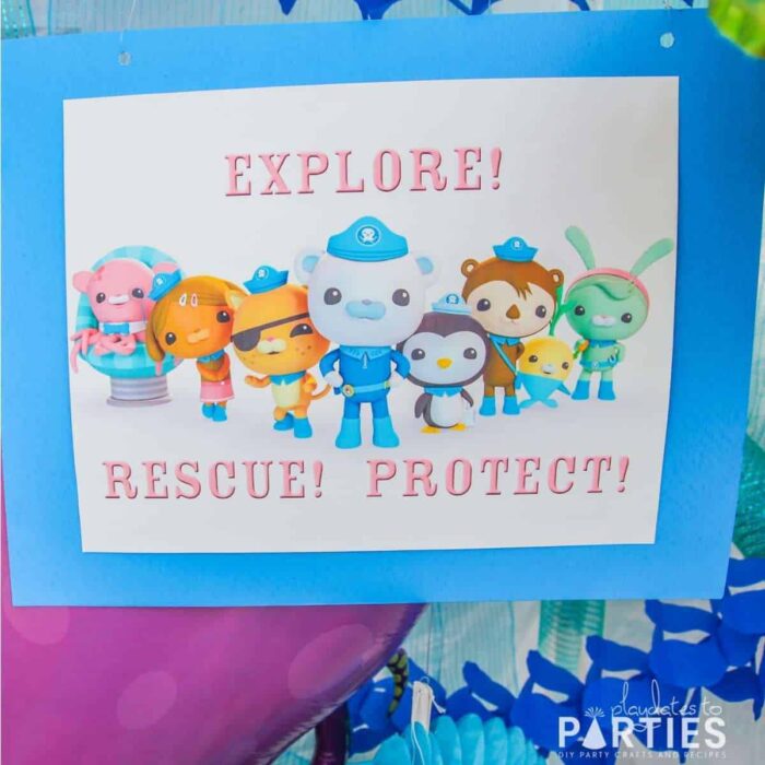 close up image of a printed sign with Octonauts team and the words Explore! Rescue! Protect!