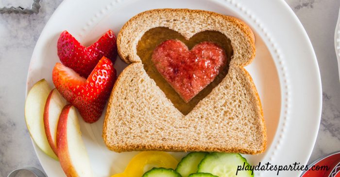 Peanut butter and jelly sandwich with a heart in the center, jelly side up