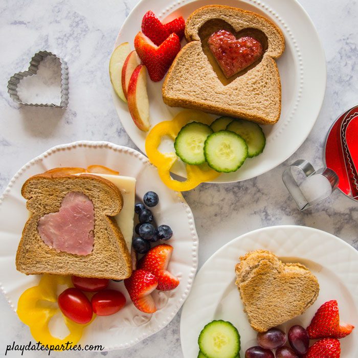 three versions of heart shaped sandwiches with fruit and vegetables