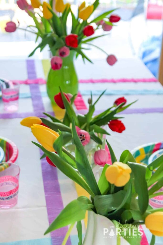 Close up of 3 vases filled with tulips as centerpieces for a kids Easter table