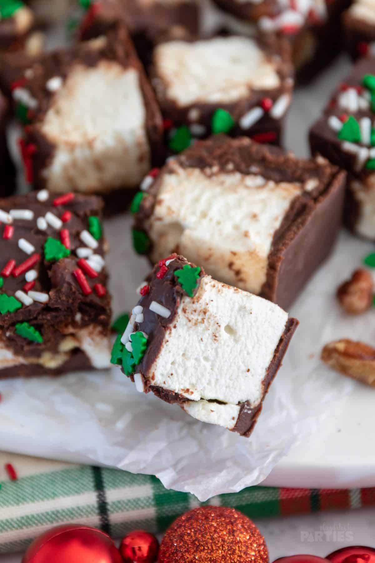 Soft pillowy marshmallows are coated in a thin layer of chocolate and decorated with holiday sprinkles.