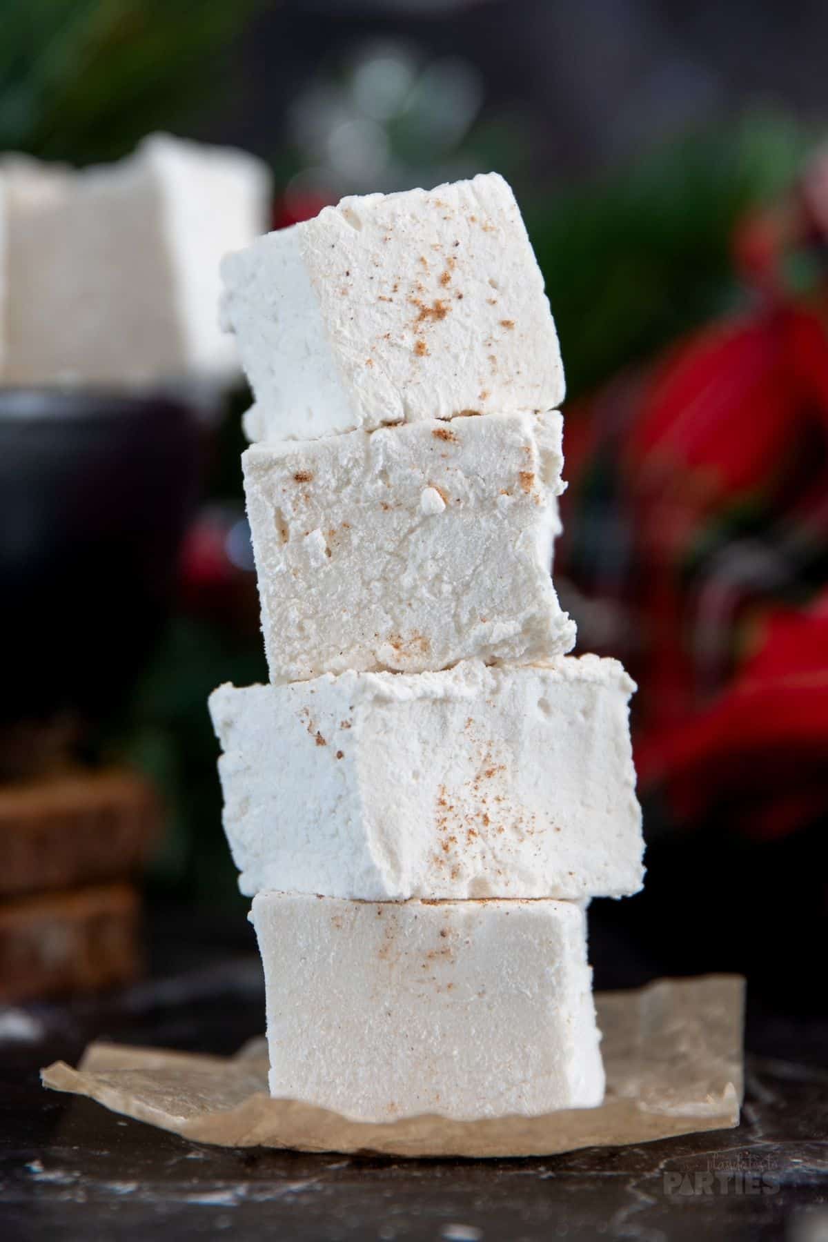 Four white homemade marshmallows dusted with nutmeg.