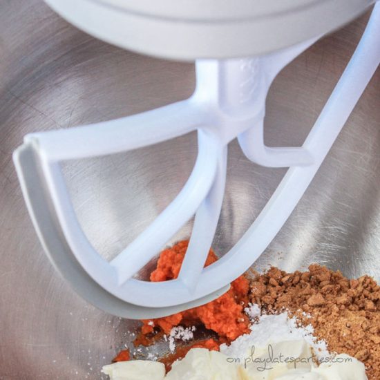 Ingredients for pumpkin pie truffles in a mixing bowl with a paddle attachment.