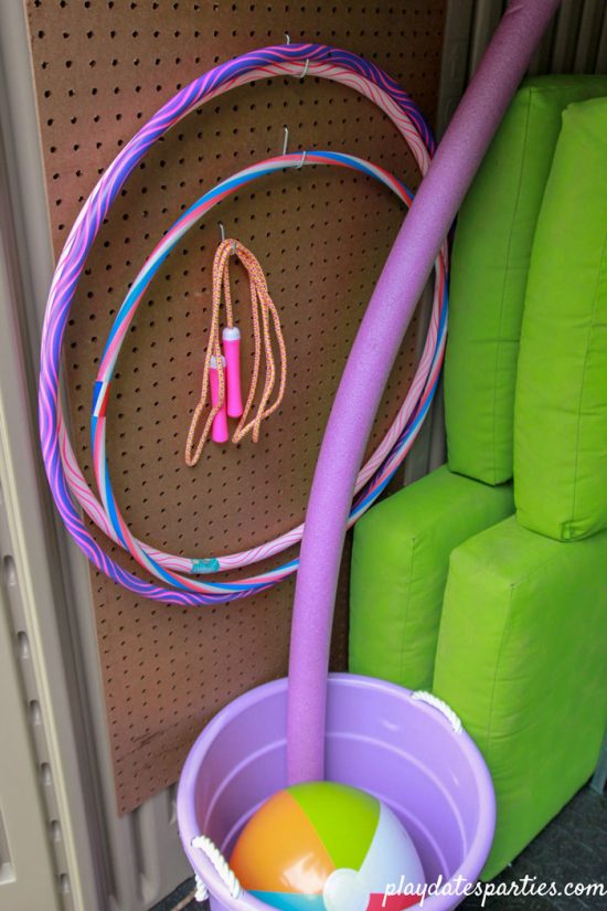 Outdoor toys on pegboard and in buckets