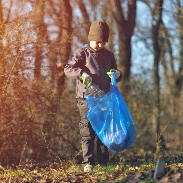 a child picking up litter outdoors