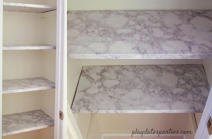 A look at linen closet shelves after applying faux marble contact paper for shelves.