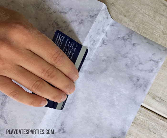 Using a credit card or smoothing tool when applying contact paper to shelves helps to get a nice sharp edge and remove any potential bubbles.