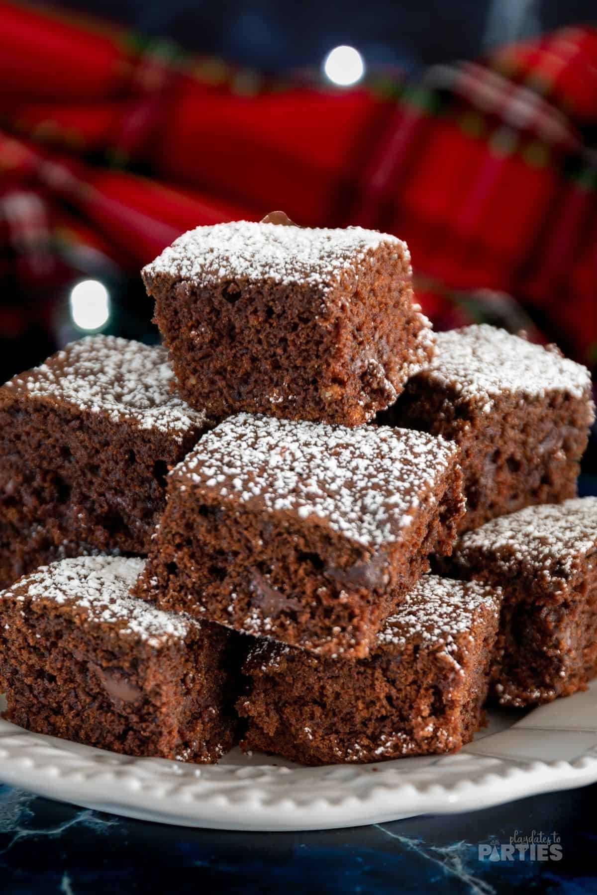 Rum and dark chocolate infused gingerbread bars piled high on a white plate.