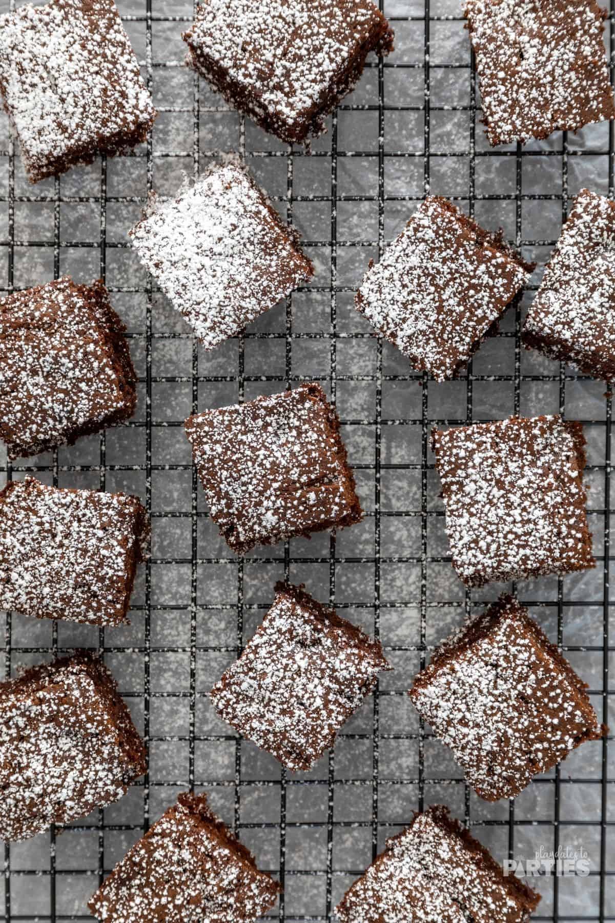 Gingerbread bars dusted with powdered sugar on a cooling rack.