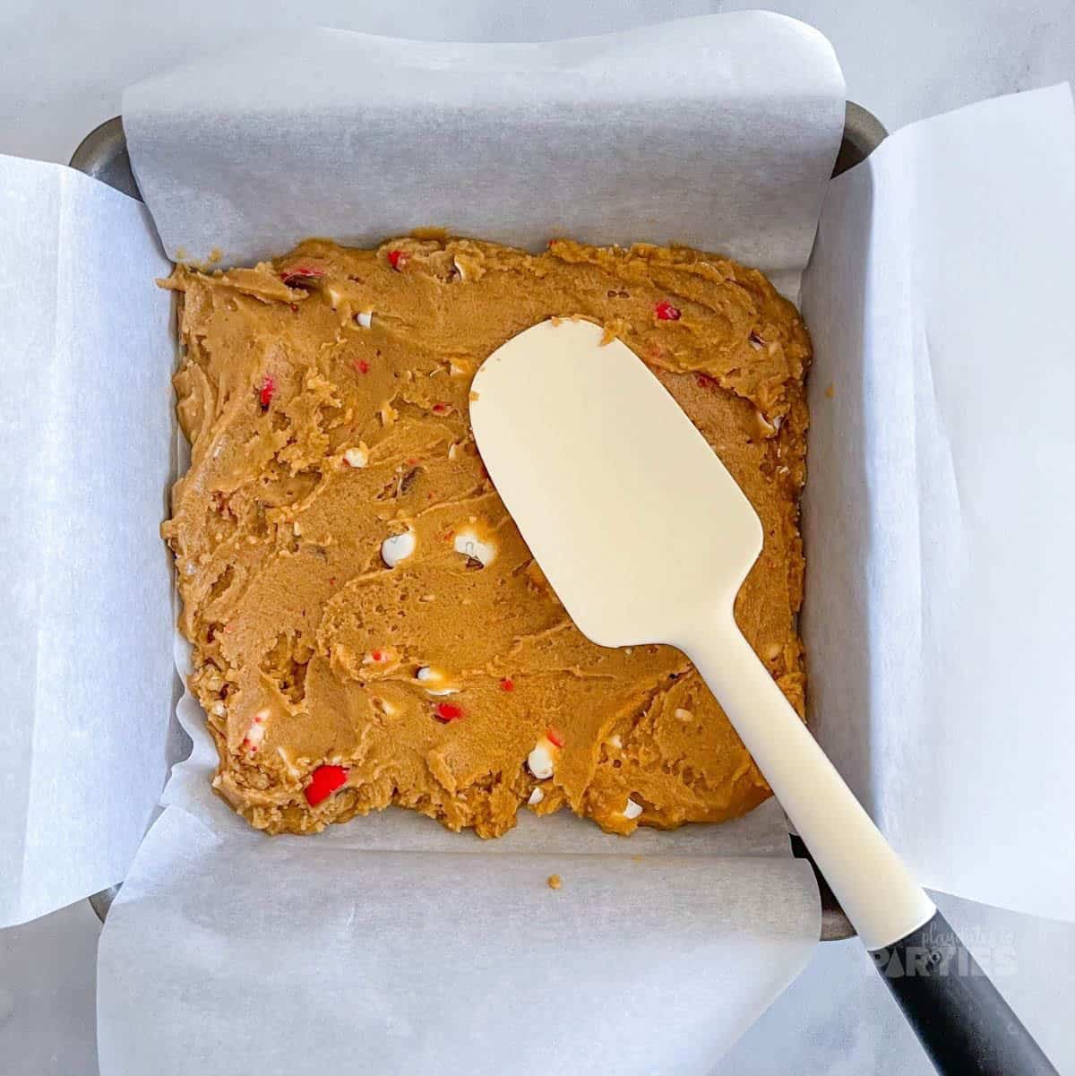 Spreading blondie batter in a pan.