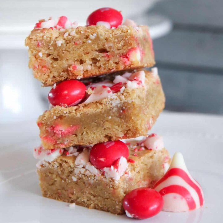 3 Peppermint blondies with white chocolate stacked on a plate.