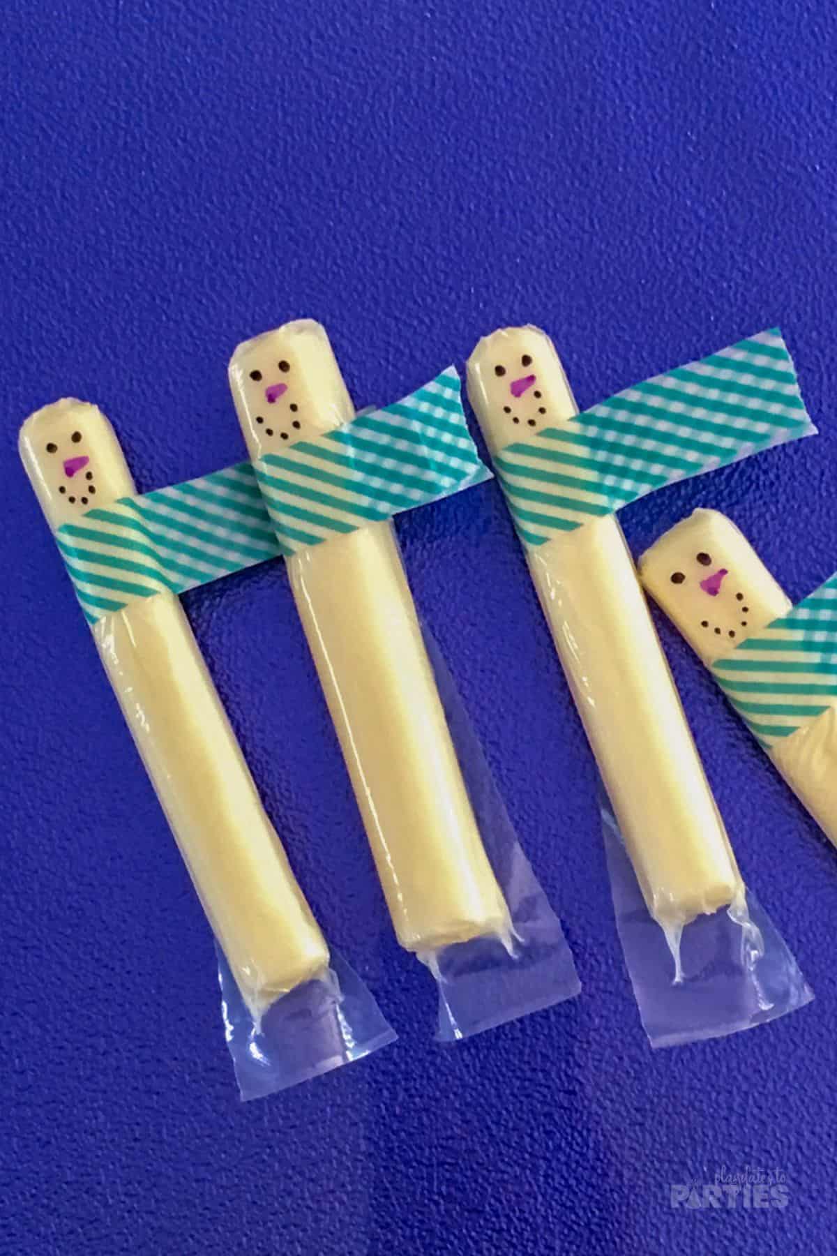 String cheese decorated as snowmen using washi tape.
