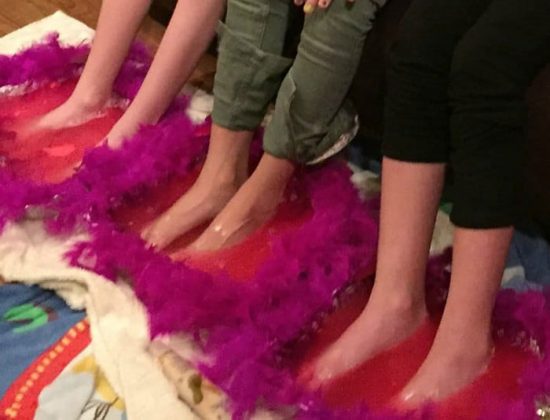 Girls getting their feet soaked at a spa birthday party.