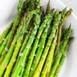 Roasted asparagus on a white plate.