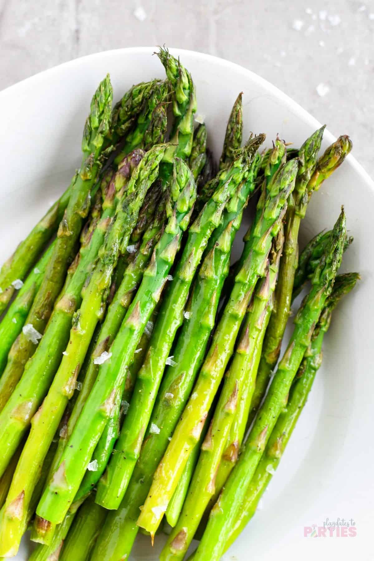 Roasted asparagus on a white plate.