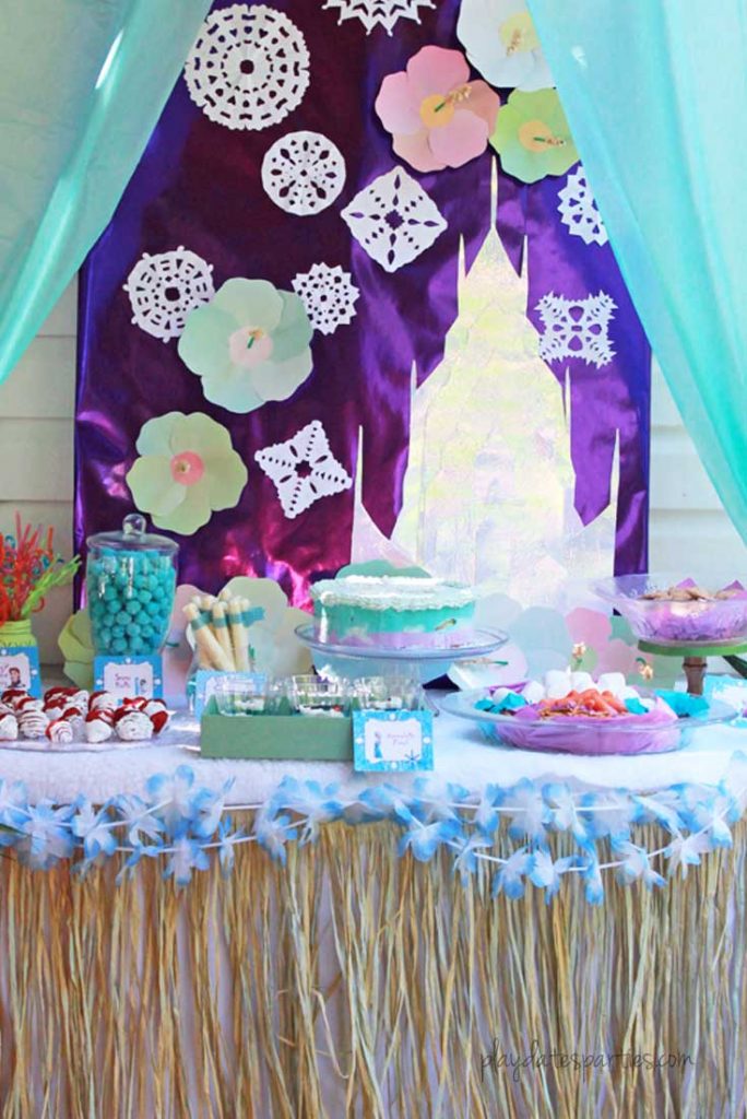 This stunning Frozen luau party is full of easy DIY projects and simple tips that you can absolutely recreate for a special little girl in your life. Including: an Olaf snow flurry, Olaf jello cups, a fake snow beach, a purple and blue ice cream cake, and lots of snowflakes everywhere!