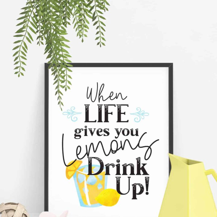 art print in a black frame that says when life gives you lemons drink up with a yellow pitcher and other decor around it