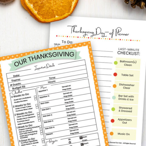 Thanksgiving dinner planner printables on a table with orange slices & pine cones