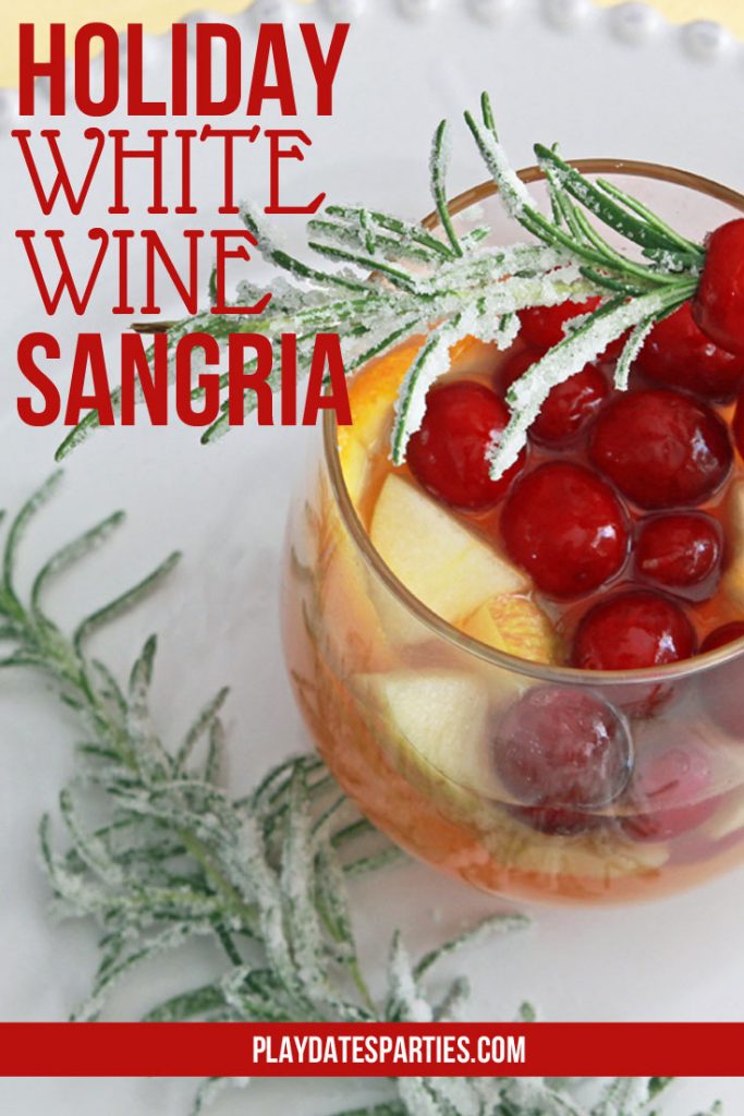 White wine holiday sangria is the PERFECT big batch drink recipe to make for your Christmas party this year. This simple recipe is fun to see and to drink with the beautiful seasonal fruit and frosted rosemary garnish.  #Christmas #ChristmasDrinks #ChristmasCocktails #CocktailRecipes #partyideas #drinkrecipes #Christmasrecipes #cocktails #wine