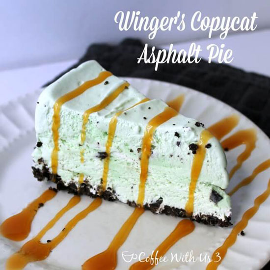 A slice of mint chocolate chip cake with an oreo cookie crust and a drizzle of caramel on top.