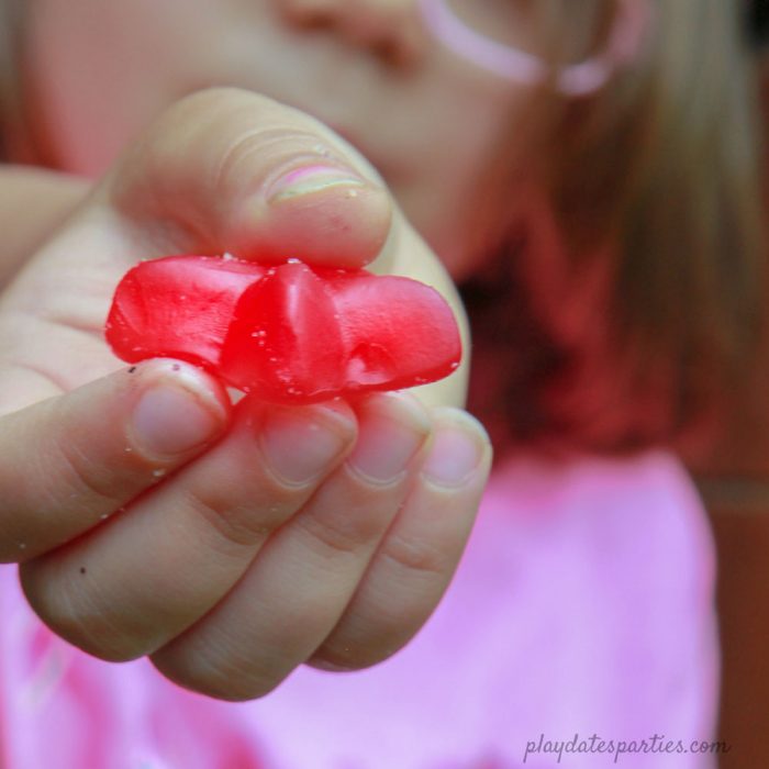 A picture of a child holding out a red gummy star