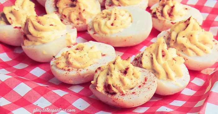 Deviled eggs on a red gingham basket liner offered as a side dish at a s'mores party 