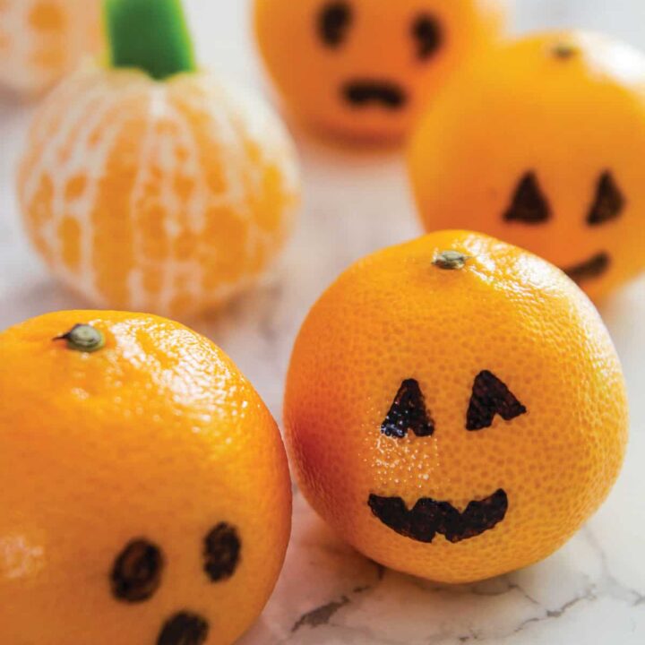 clementines on a table made to look like jack o lanterns and pumpkins