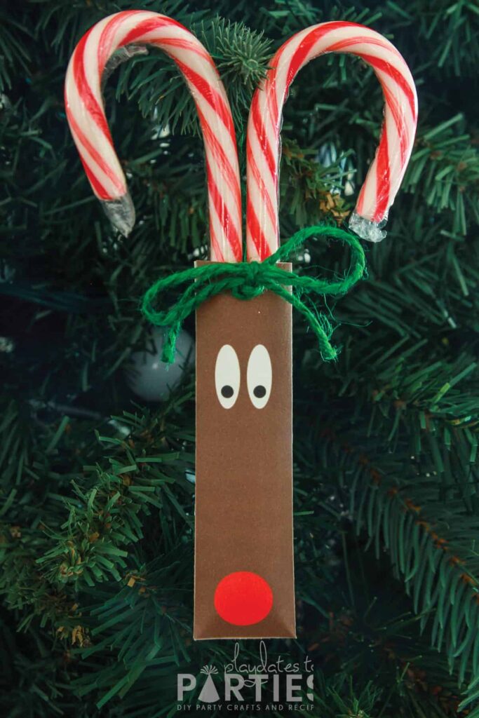 reindeer candy cane craft turned into an ornament and hanging on a Christmas tree