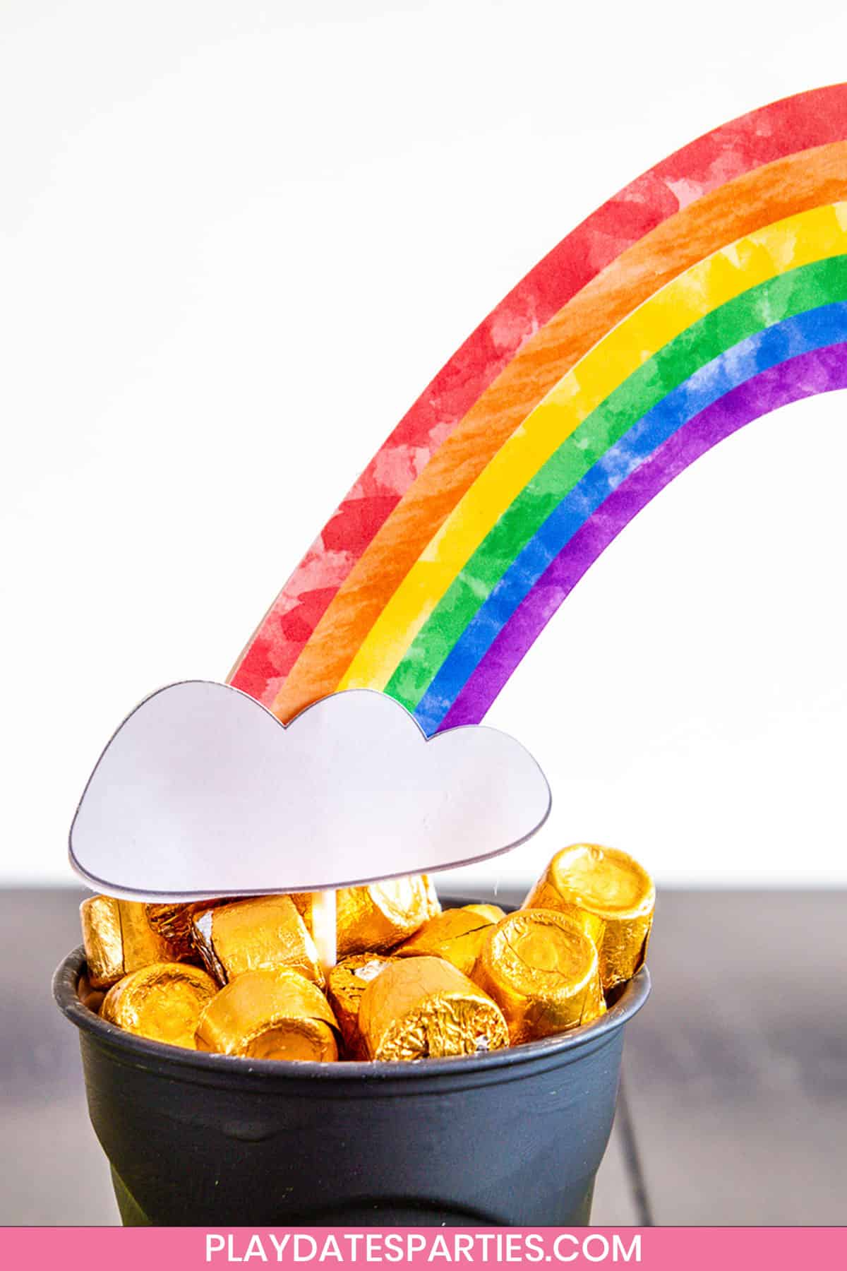close up of a cup full of Rolos with a paper craft rainbow coming out of it