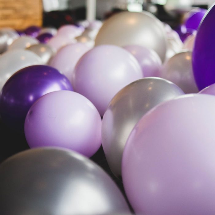 Hundreds of balloons without helium filling the floor of a room