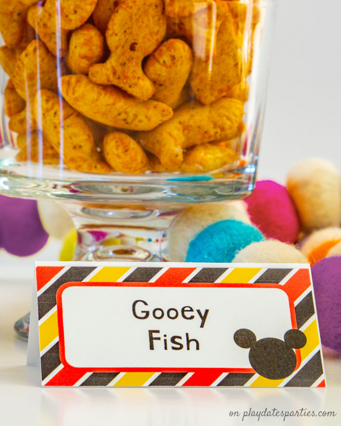 A bowl of goldfish crackers with a Mickey Mouse themed table card and the title Gooey Fish