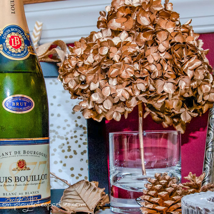 Close up of gold painted hydrangea, leaves, and pine cones on a Thanksgiving bar