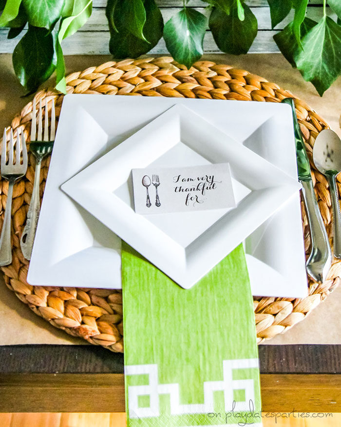 Inexpensive Thanksgiving table setting with disposable plates, woven placemats and a brown paper tablecloth