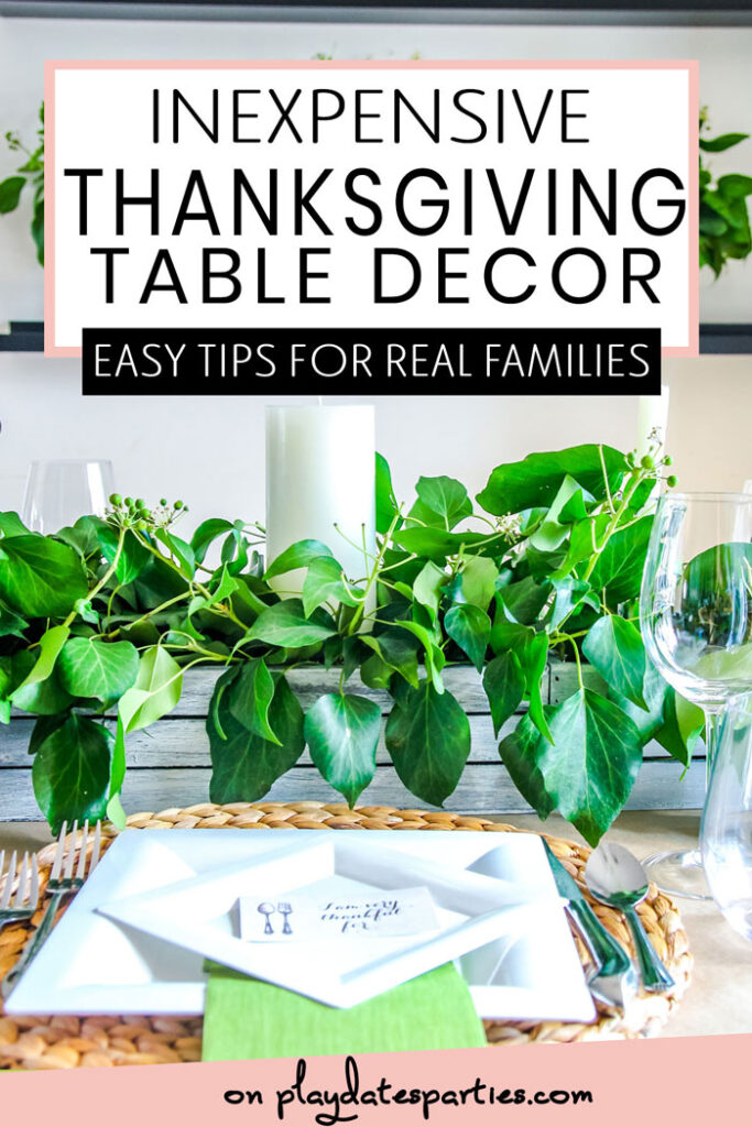 Thanksgiving table set with white plates greenery and candles with the text inexpensive Thanksgiving table decor. Easy tips for real families