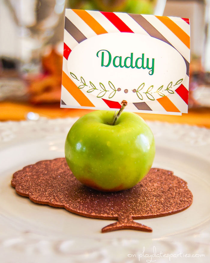 Vintage style Thanksgiving plates with a gold turkey cutout and a fresh apple as a place card holder