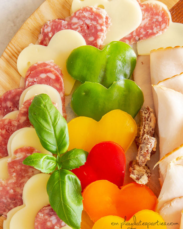 close up of heart shaped vegetables, swiss cheese, and salami