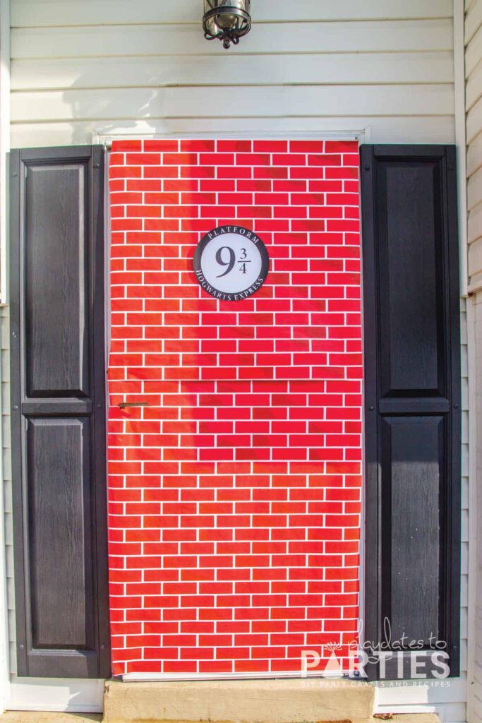 front door covered with brick paper and a sign that says platform 9 3/4