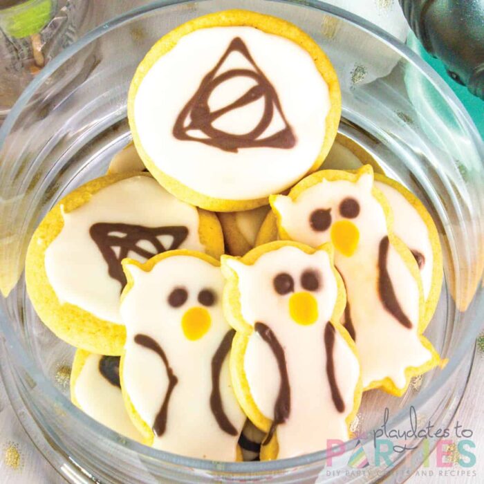 Sugar cookies shaped and decorated to look like the deathly hallows and white owls