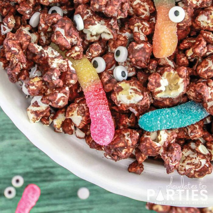 close up of a bowl of Halloween monster munch on a teal table